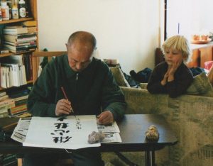 Xing Yi Quan Grand Master Liang Ke Quan writes calligraphy while Connor observes intently